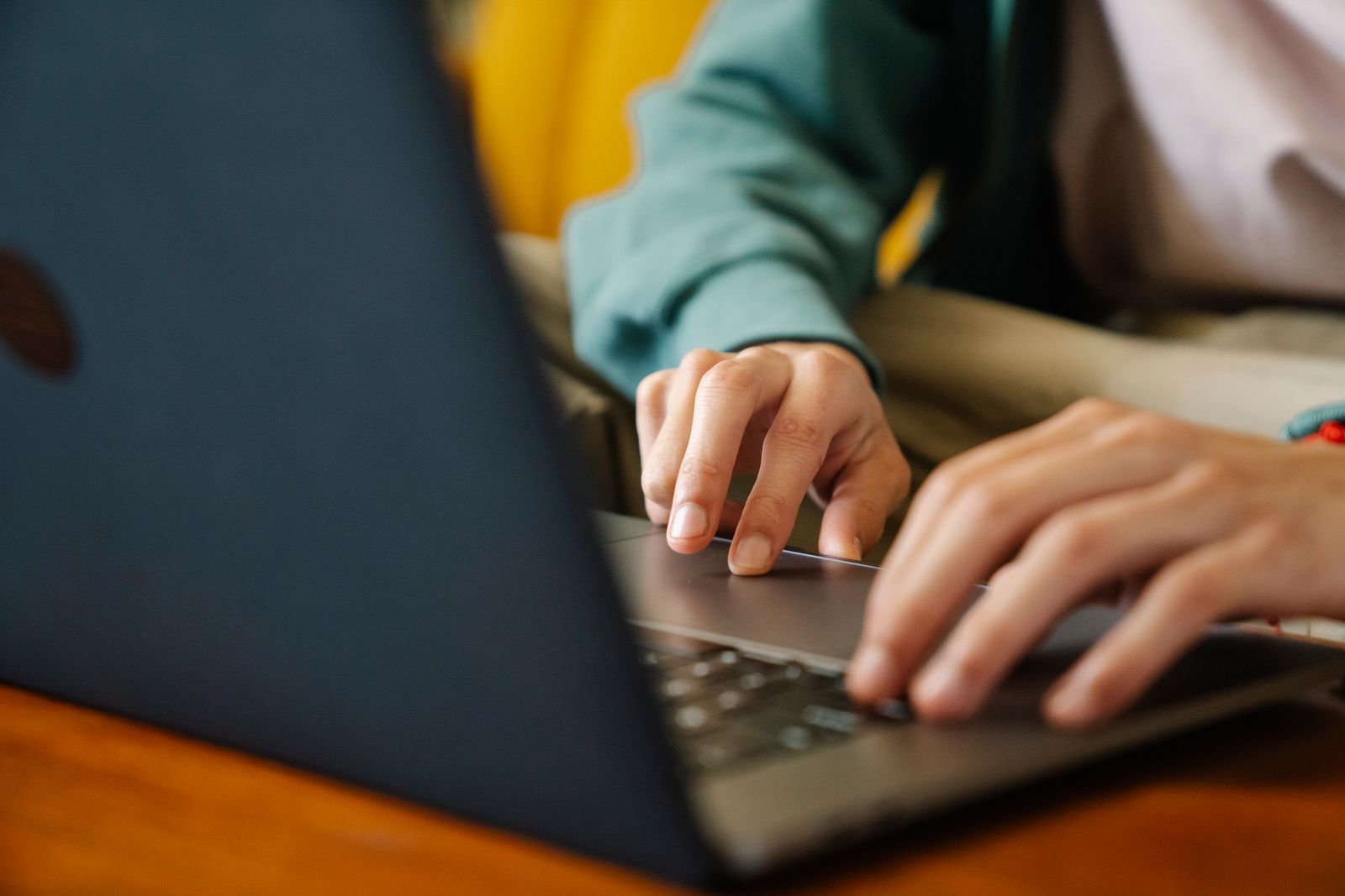 Young adult reviewing paperwork on a laptop outdoors