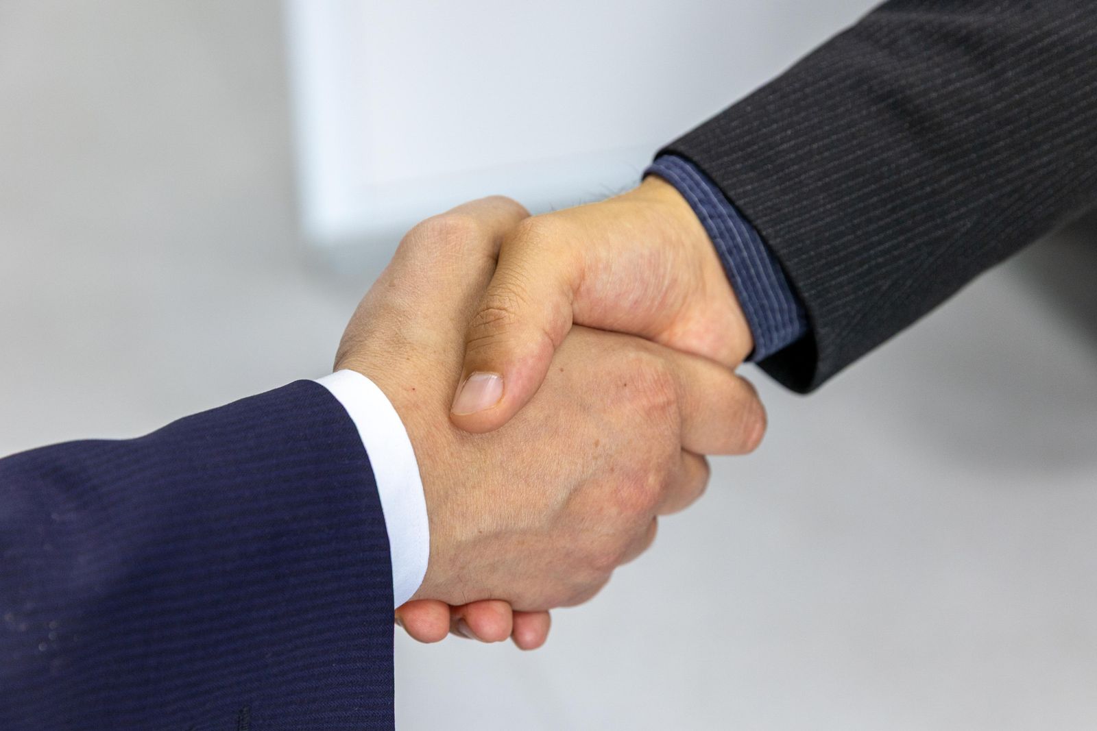Two people shaking hands in business attire