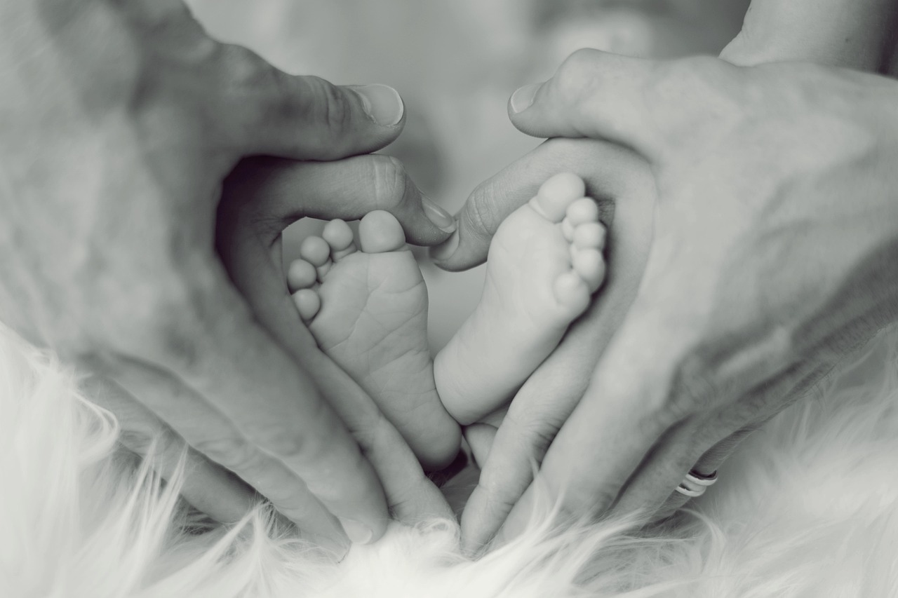 A mother gently holding her newborn baby close in a bright, calm room