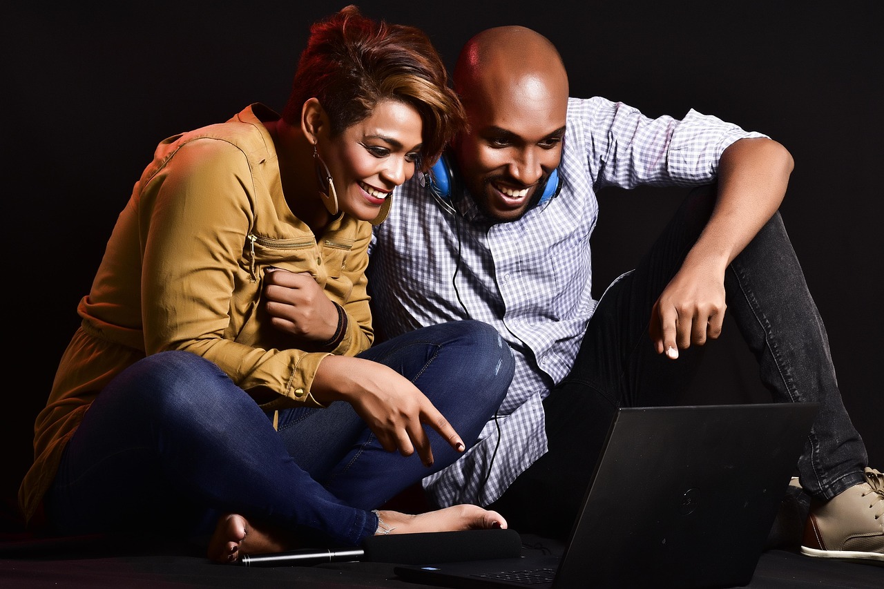 A smiling couple sitting together at home, talking through plans for the year ahead