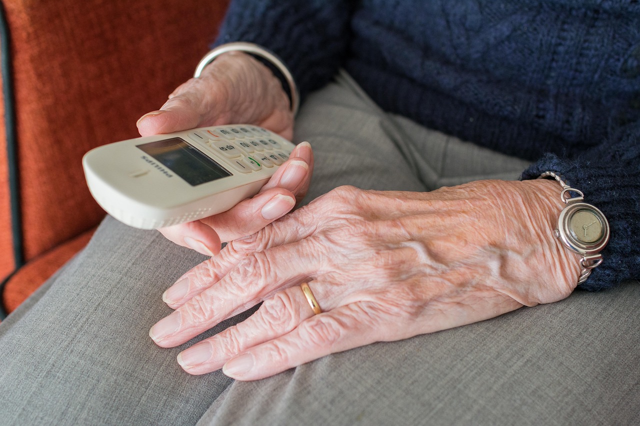 A woman at home talking on the phone with a thoughtful expression