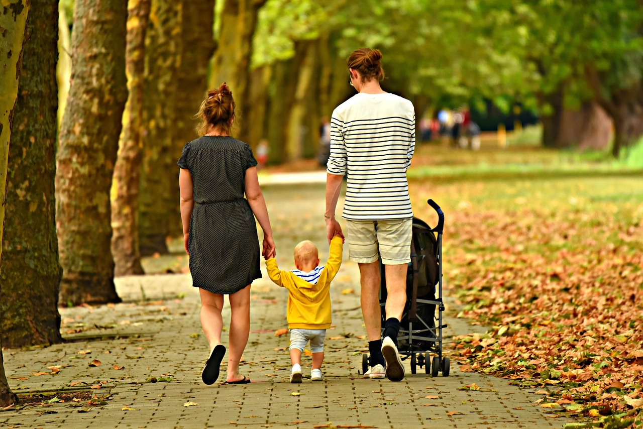 A happy family with children walking together in a park on a fall day