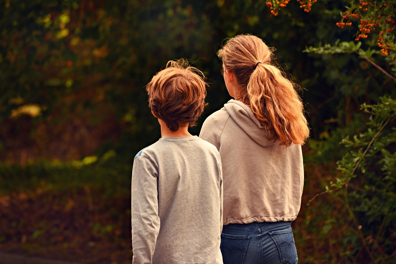 Parents and children walking together along a sunny park path