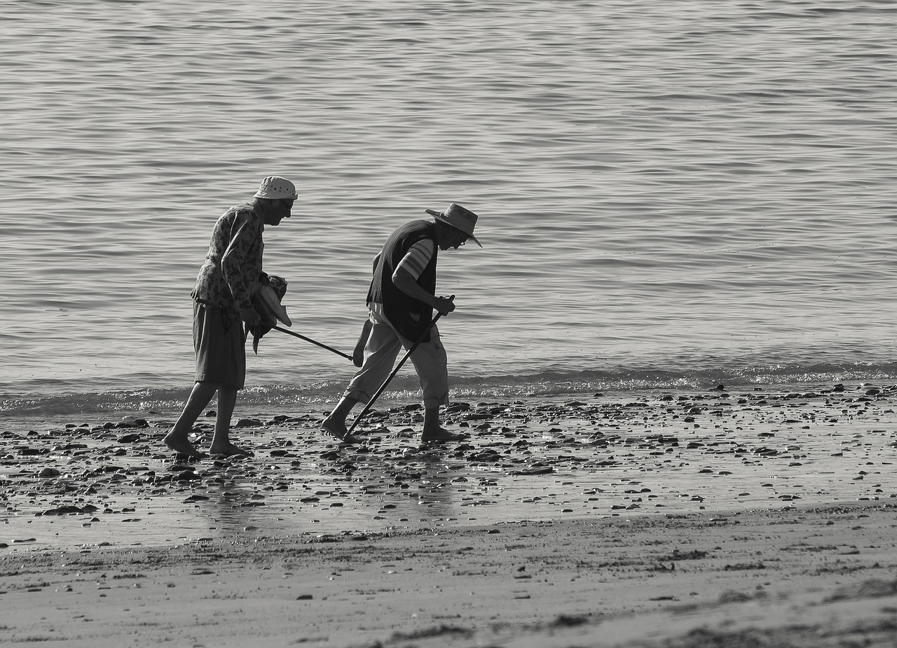 A smiling older couple walking together along a sunny beach