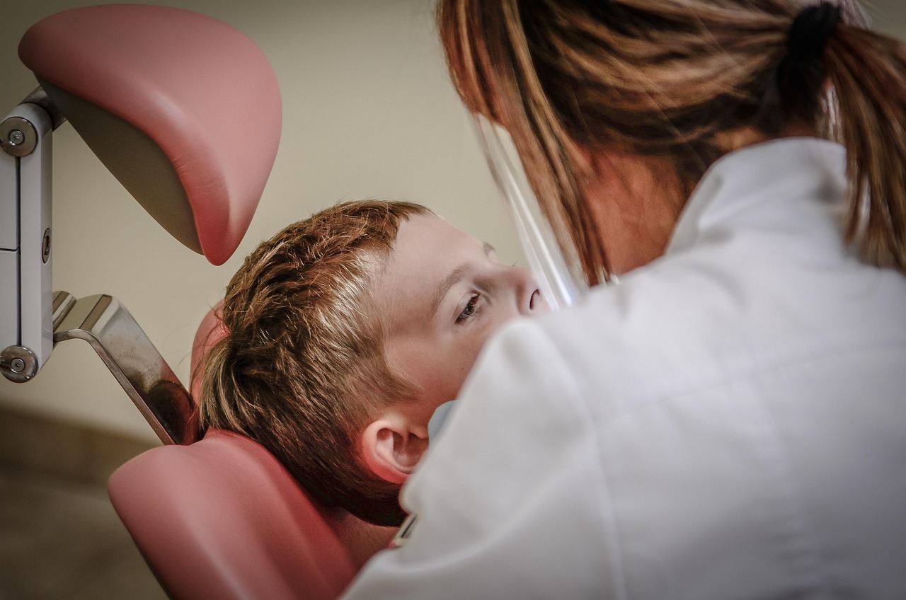 A friendly dentist talking with a smiling child in a bright dental office
