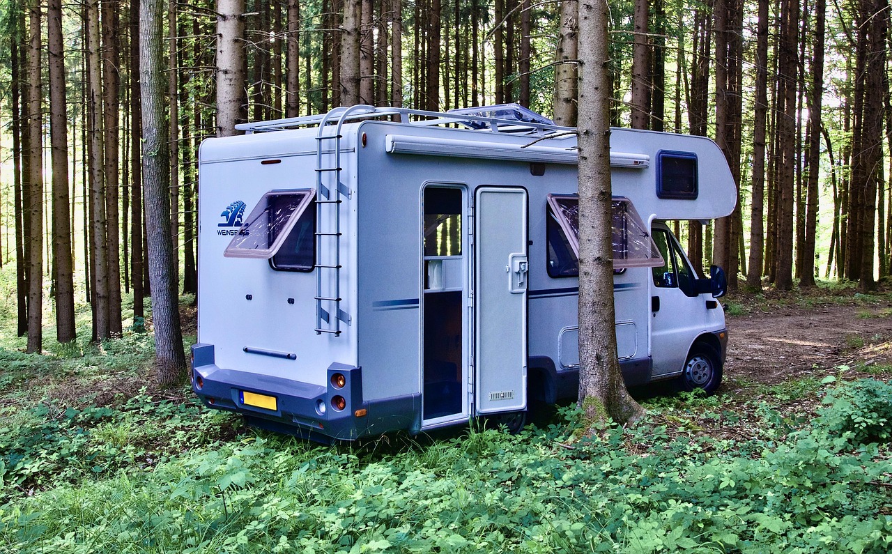 A relaxed couple sitting outside their RV at a scenic campsite