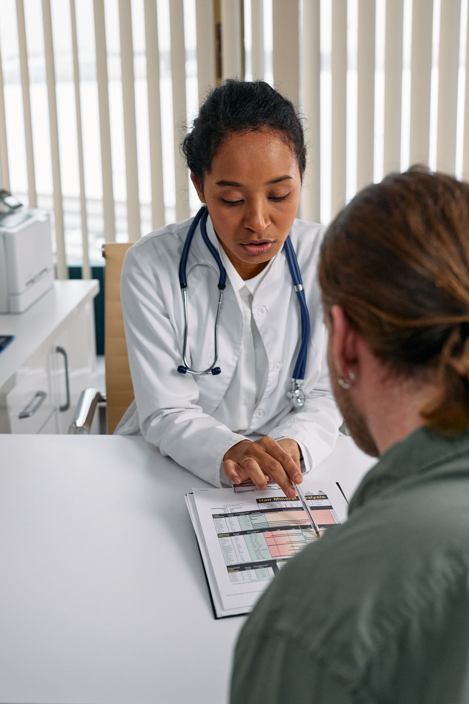 Doctor reviewing a patient's health results together in a clinic office